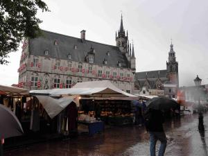 Goudské náměstí Markt s radnicí a kostelem Sint Janskerk (kostel sv. Jana), v popředí prodejní stánek se sýry