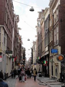 Ulice Warmoesstraat vede čtvrtí De Wallen (čtvrť červených luceren), Amsterdam